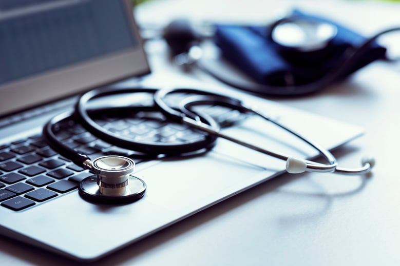 stethoscope on top of a laptop