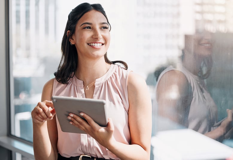 worker smiling while holding tablet