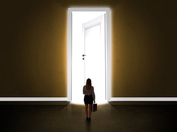 Business woman looking at big bright opened door concept