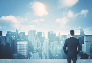 Businessman standing on a roof and looking at future city