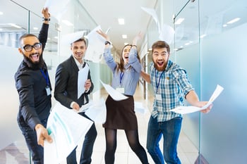 Group of joyful excited business people throwing papers and having fun in office-4