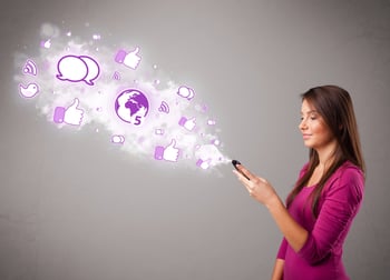 Pretty young girl holding a phone with social media icons in abstract cloud-1