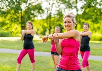 Smiling jogging coach stretching in th park