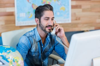 Smiling travel agent having phone call in the office