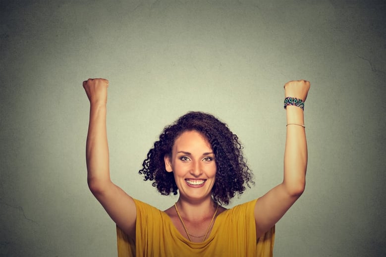 Successful woman with arms up celebrating
