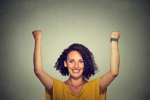 Successful woman with arms up celebrating