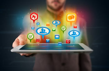 Young businessman presenting modern tablet with colorful social signs and icons