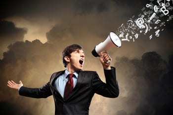 young businessman in black suit screaming into megaphone