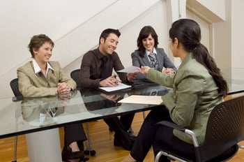 Woman handing over resume at meeting.