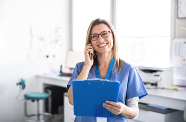 healthcare professional holding a blue clipboard while on the phone