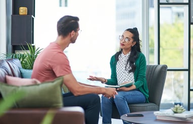two people sitting in an office setting having a conversation