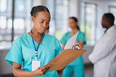 nurse reviewing information on clipboard