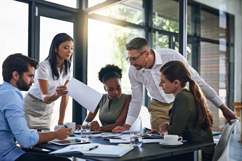 business people seated at a table looking over documents