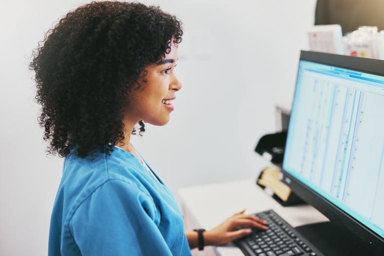 healthcare professional seated in front of a computer screen