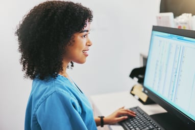 healthcare professional seated in front of a computer screen