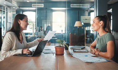 Job interview for a business woman at a hiring company talking to the HR manager about the role or position. Young female applicant or candidate in a meeting with an employer having a discussion