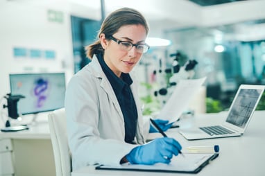 clinical research professional in a lab taking notes