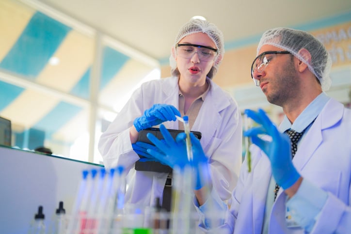 scientists perform experiments and record data. people arranges equipment with test tubes and chemicals for producing medicine and biochemistry. man hold tubes of chemical liquids and plant samples.