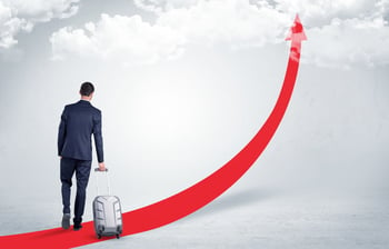 Young businessman with back leaving on the red arrow carpet to the skies with luggage on his hand