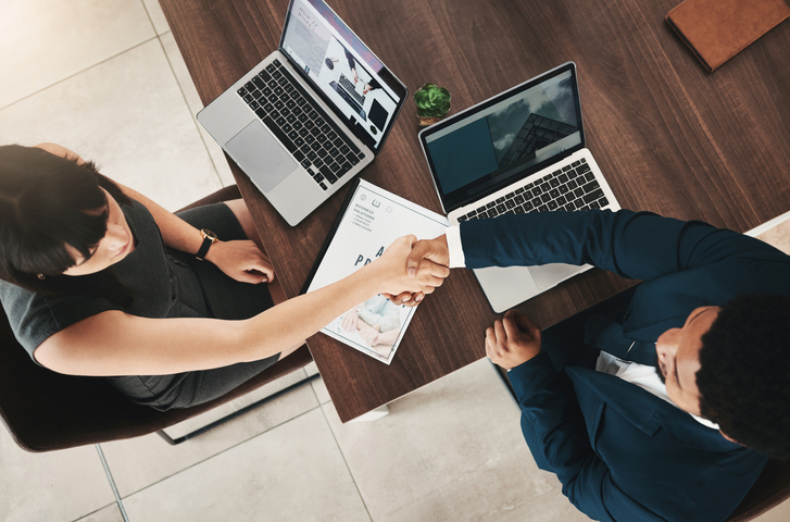 Man and woman shaking hands in an office environment