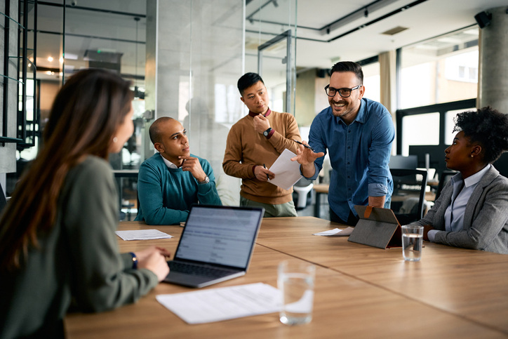 Happy entrepreneur leading a business meeting with coworkers in the office