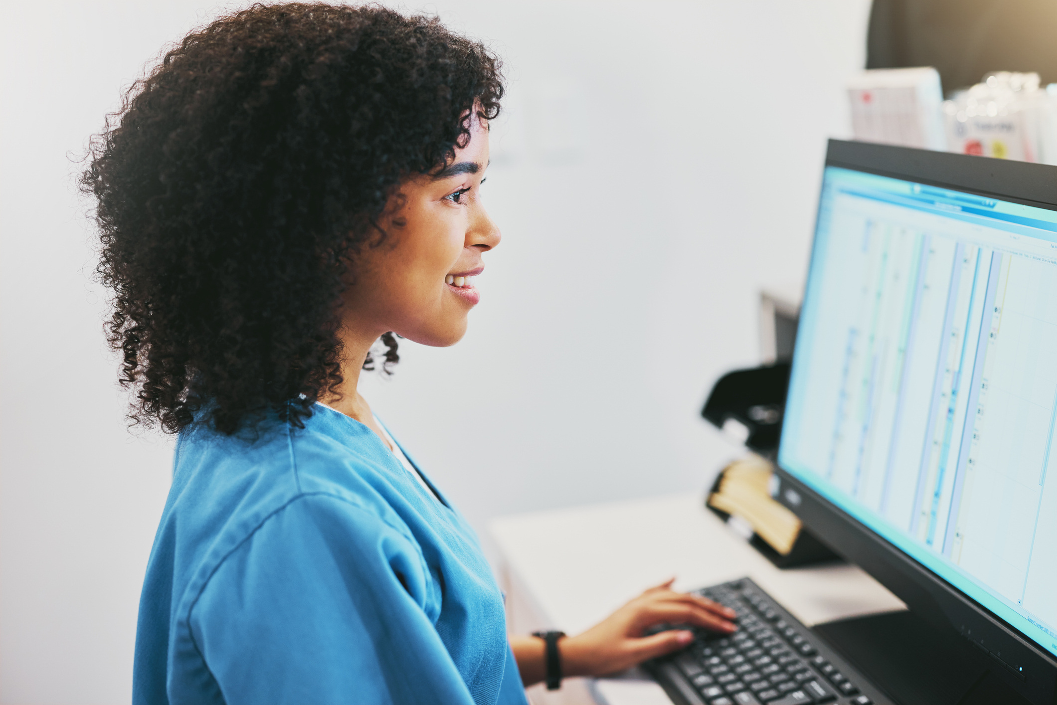 healthcare professional seated in front of a computer screen